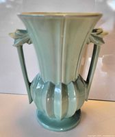 Front view of light green McCoy vase showing flared rim, ribbed body, handles, and base