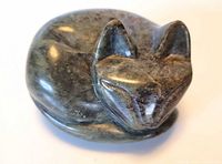 Front view of signed stone sleeping cat carving