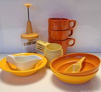 Group shot of all Tupperware pieces including chopper, mugs, bowls, measuring cups, gravy boat, scoop