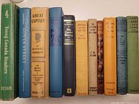 Spines of all twelve books lined up for title and condition reference