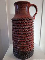 Front view of tall red spiral textured vase
