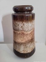 Full view of cylindrical cream and brown glazed vase