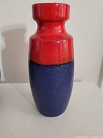 Front view of tall red and purple glazed West German vase