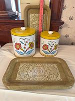 Front view of canisters and two of the trays showing design and scale