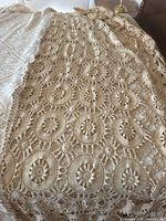 Full view of crochet lace tablecloth showing circular medallion pattern and overall color