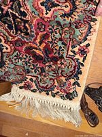 Corner of rug showing multicolor floral pattern and fringe