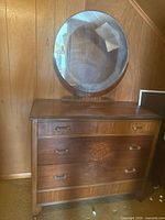 Front view showing dresser, three drawers, attached round mirror