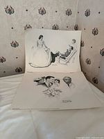 Both Norman Rockwell prints laid out on surface