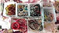 Six bins filled with assorted costume jewelry pieces