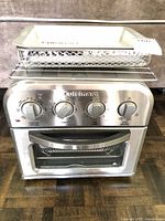 Front view of Cuisinart TOA-28BBC air fryer toaster oven with accessories on top