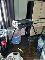 Full view of black wooden tripod easel with box closed