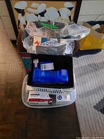 Stacked containers showing tissue boxes, bandages, and assorted health-care products