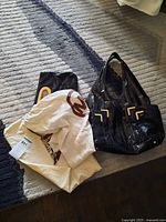 Handbag with two dust bags laid out on rug