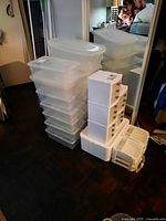 Stacks of clear plastic totes, white drawer units and open bins