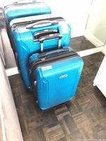 Two blue Samsonite suitcases standing side by side
