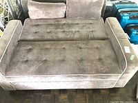 Sofa in bed position showing tufted seat surface