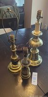 Three brass-tone lamp bases grouped on table