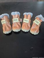 Front view of all four dog boots showing uppers, straps, and fur trim