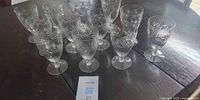 Group shot of all 12 clear starburst pattern stemmed glasses on table