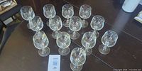 All 13 matching clear wine glasses arranged on table