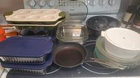 Overview of all bakeware, colanders, plates, frying pan on stove