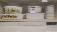 Group of CorningWare dishes arranged on shelf