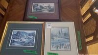 Front view of all three framed prints on table