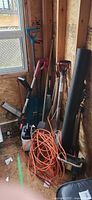 Group of long-handled tools, trimmer, sprayer, cord, fabric roll