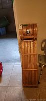 Full view of wooden toboggan leaning against wall