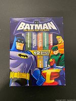 Front of Batman Book-Block library showing 12 book spines and DC characters