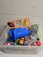 Overall view of bin with Duplo blocks, wooden puzzle board, vehicles and accessories
