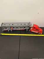 Full side view of carrier truck with measuring tape
