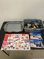 Overall lot with bin, lid, instruction poster, and two Dueling Racers boxes
