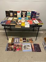 Full view of table and floor showing quantity and variety of books and calendars
