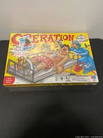 Front view of sealed Operation board game box