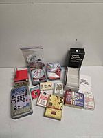 All items laid out: Cards Against Humanity box and cards, oracle deck, domino tins, playing card decks, magic set