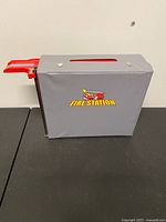 closed gray carry case with Fire Station graphic and red ramp
