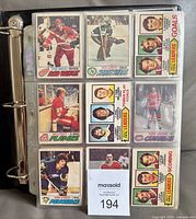 Binder open showing multiple 1977-78 OPC hockey cards in plastic pages