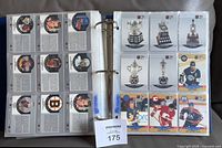 Binder opened showing plastic pages with trophy and player cards