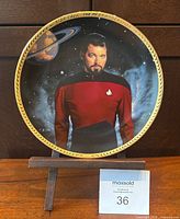 Front view of plate on stand showing Riker image and gold rim