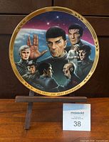 Front view of plate on stand showing artwork and gold rim