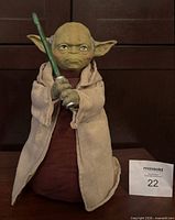 Front view of Yoda figure holding lightsaber