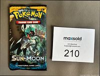 Front of sealed Pokémon Sun & Moon booster pack with Decidueye artwork beside lot card 210