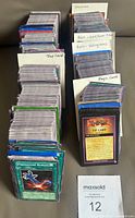 Stacks of categorized Yu-Gi-Oh! cards with handwritten labels for Japanese, rare gold/silver titles, rare holograms, trap, and magic cards