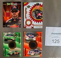 Fronts of four NASCAR memorabilia cards showing swatches and serial numbers