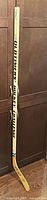 Full view of the signed Oldtimers Hockey Challenge stick standing upright