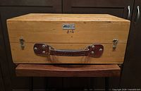 Front view of wooden box showing handle, latches, Kern badge