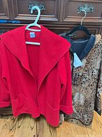Both coats hanging red front, leopard side visible