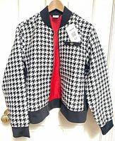 Front view of Adidas houndstooth bomber jacket hanging