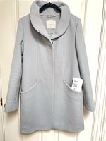 Full front view of light blue Wilfred coat on hanger showing overall style and length